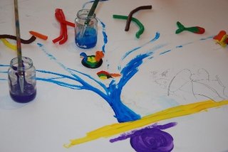 Ein Bild in blau und gelb auf weißem Hintergrund, auf dem Bild stehen Gläser mit Farben und Pinseln.